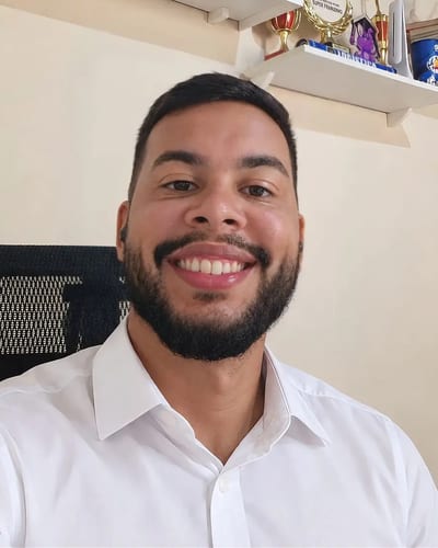 Pedro Portela, fundador da Portela Systems, sorrindo de camisa branca no escritório